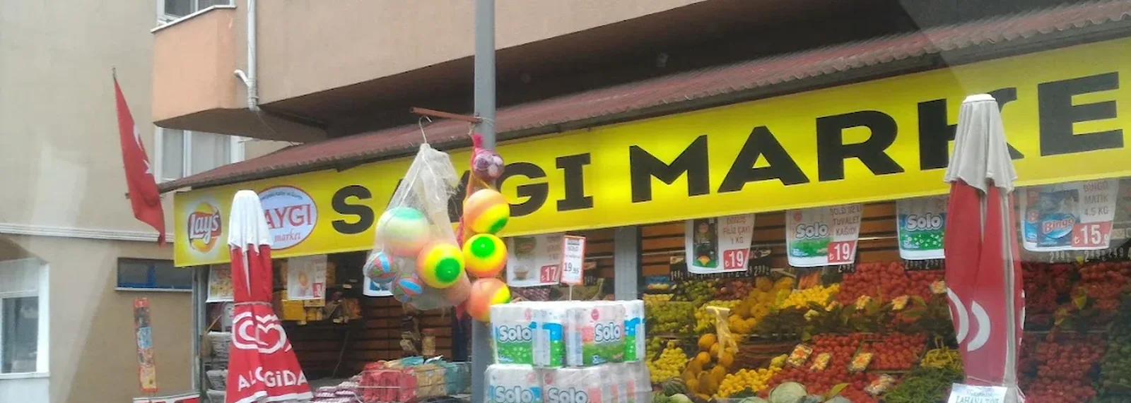 Saygı Market'in Evliya Çelebi'deki dükkânı; sarı tabela ve sebze-meyve reyonu
