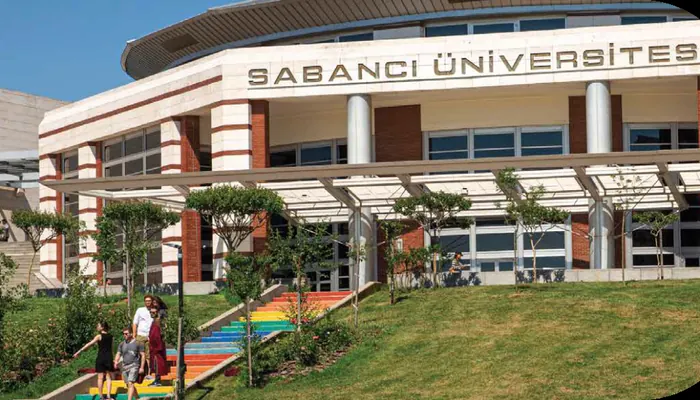 Sabancı Üniversitesi binasının cephesi: üst katta üniversite adı, önünde gökkuşağı renklerine boyanmış merdiven